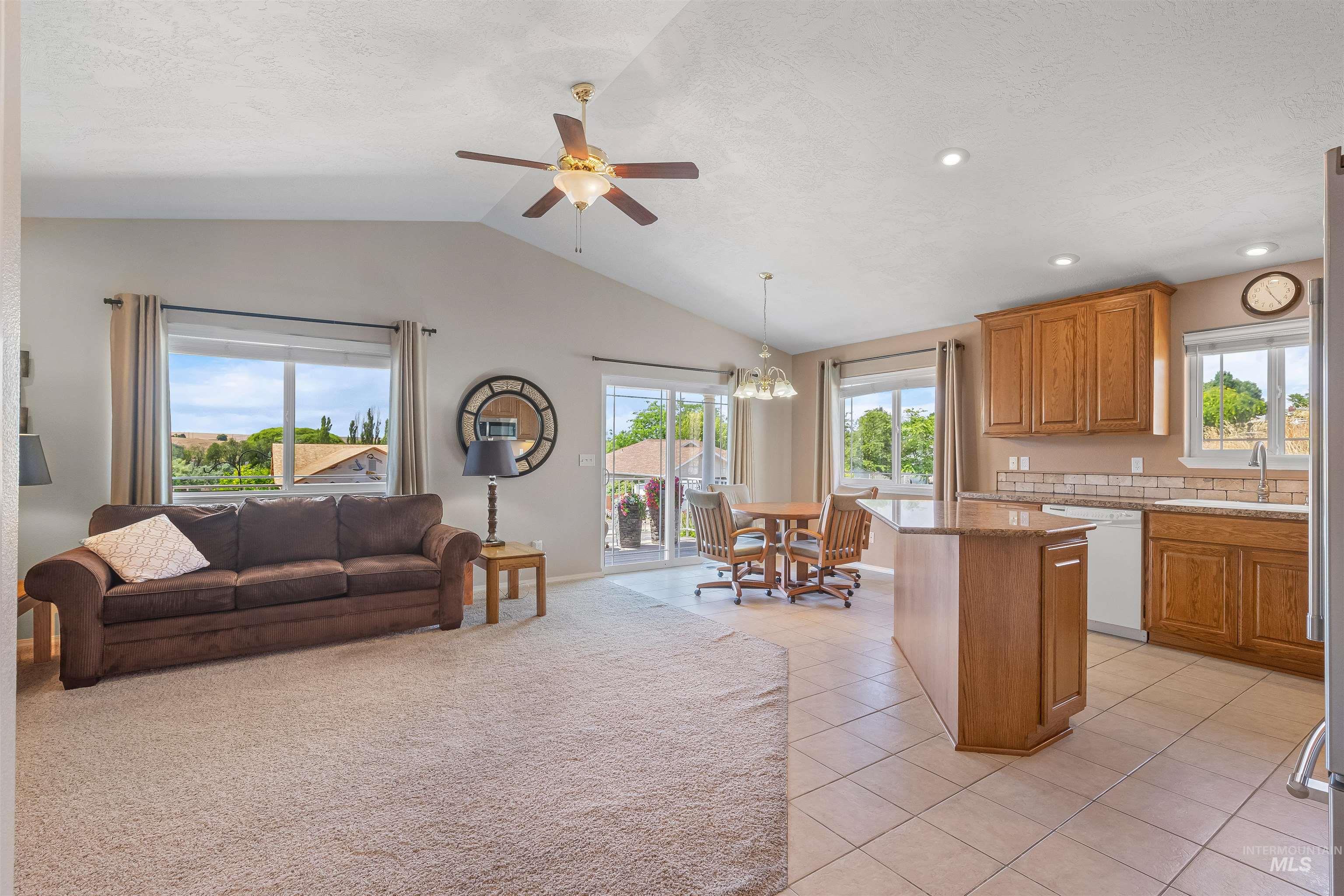 935 Grelle Avenue Lewiston, ID 83501 - Photo 33 of 33 Kitchen featuring dishwasher, open floor plan, vaulted ceiling, ceiling fan, and brown cabinetry