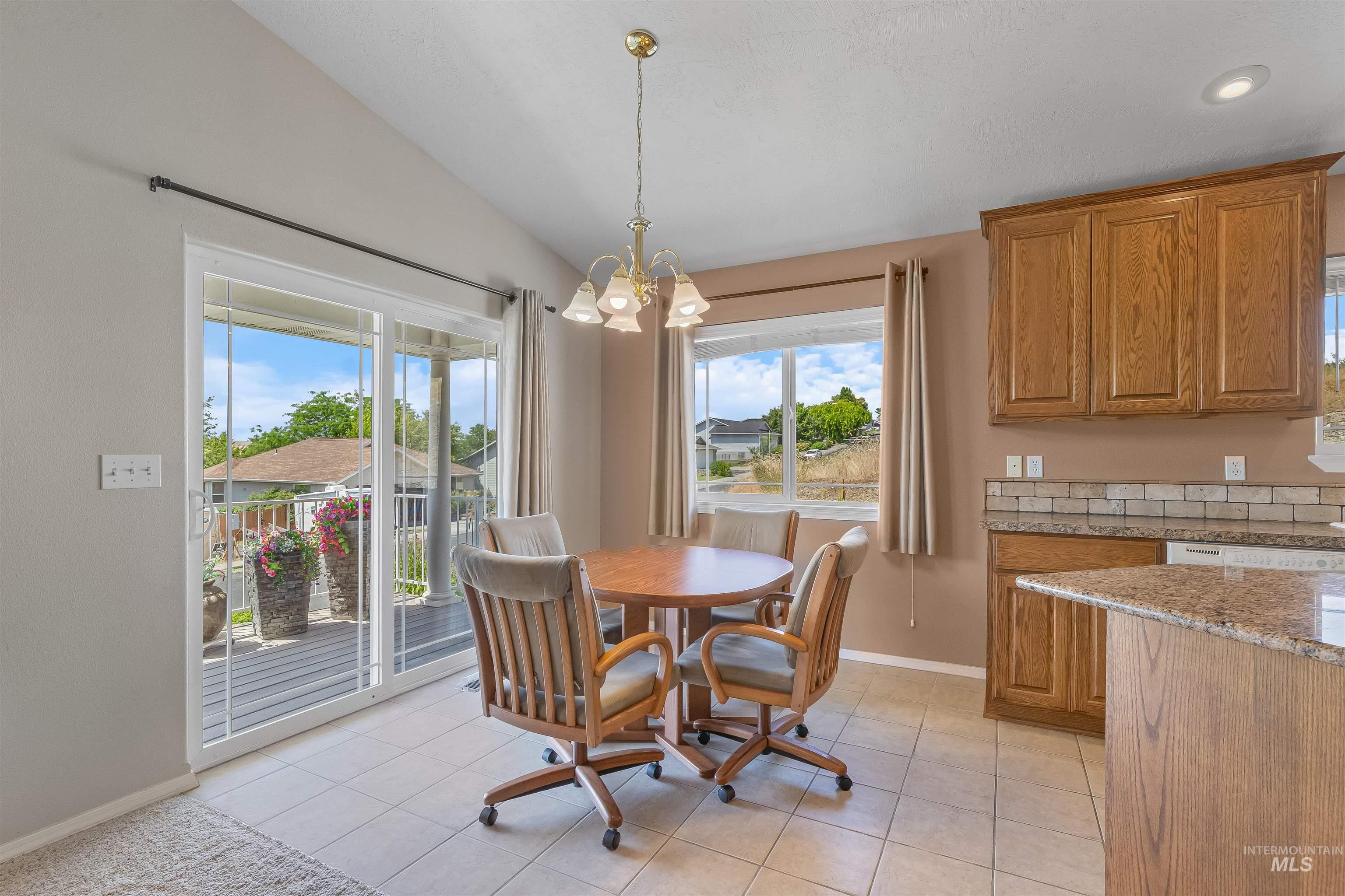 935 Grelle Avenue Lewiston, ID 83501 - Photo 14 of 33 Dining space featuring a chandelier, lofted ceiling, healthy amount of natural light, and light tile patterned floors