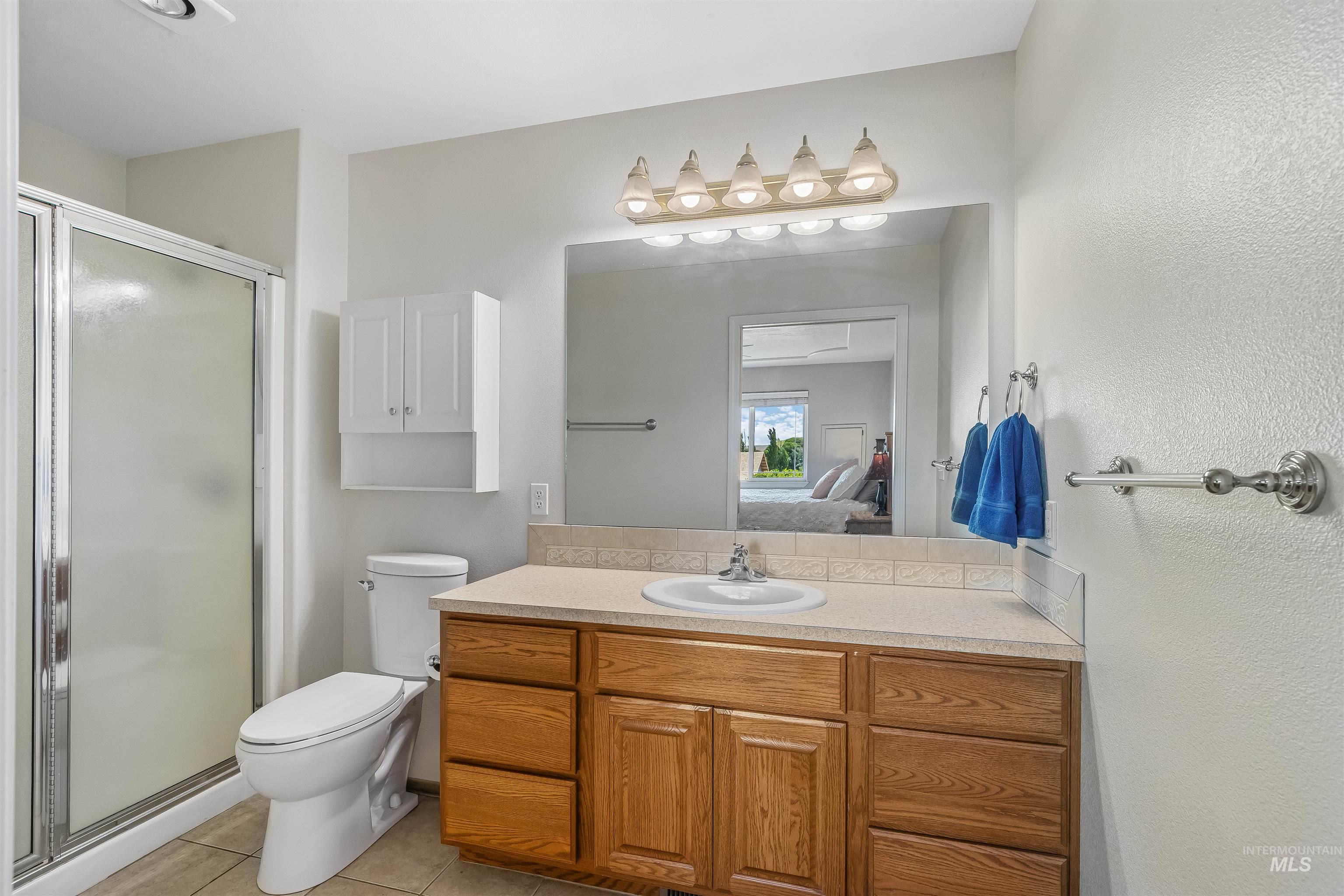 935 Grelle Avenue Lewiston, ID 83501 - Photo 25 of 33 Ensuite bathroom featuring a shower stall, tile patterned flooring, and vanity