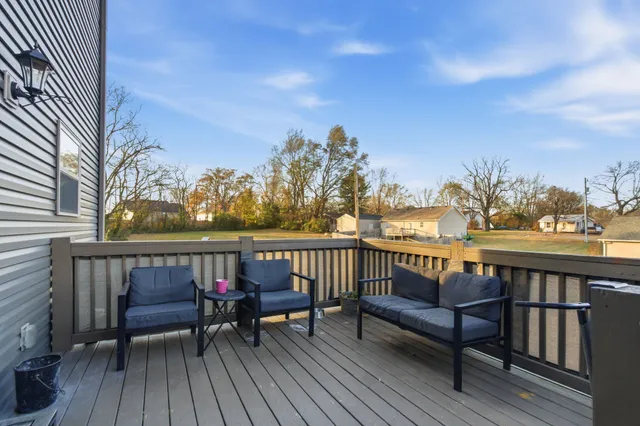 a view of a roof deck with wooden floor and city view