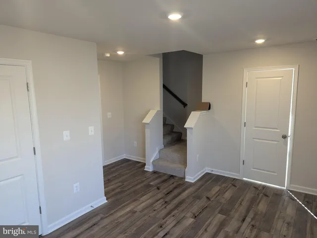 a view of hallway with stairs and wooden floor