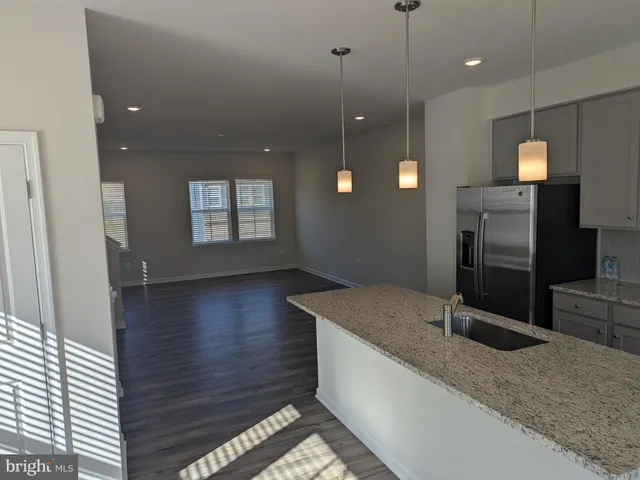 a kitchen with stainless steel appliances granite countertop a sink a stove and a wooden floors