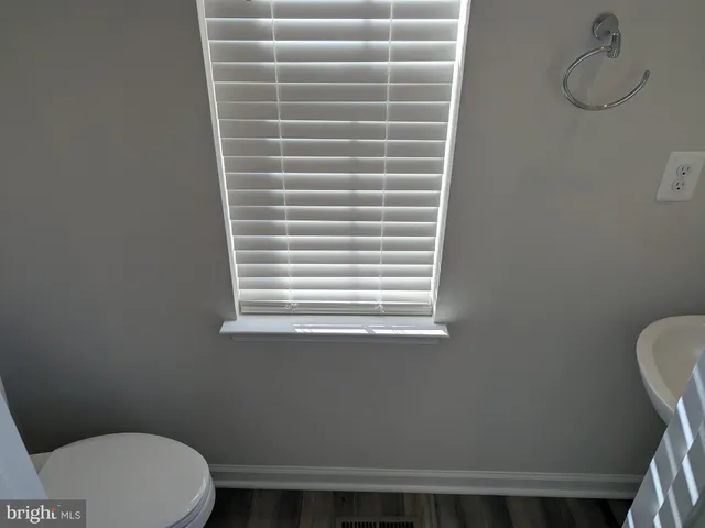 a bathroom with a toilet and a window