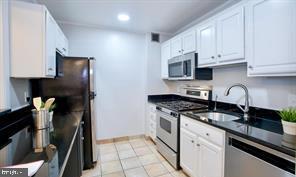 1280 21st Street Northwest, Unit 109 Washington, DC 20036 - Photo 21 of 22 a kitchen with granite countertop a stove sink and cabinets