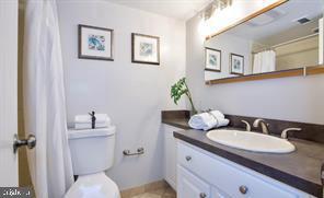1280 21st Street Northwest, Unit 109 Washington, DC 20036 - Photo 6 of 22 a bathroom with a granite countertop toilet sink and mirror