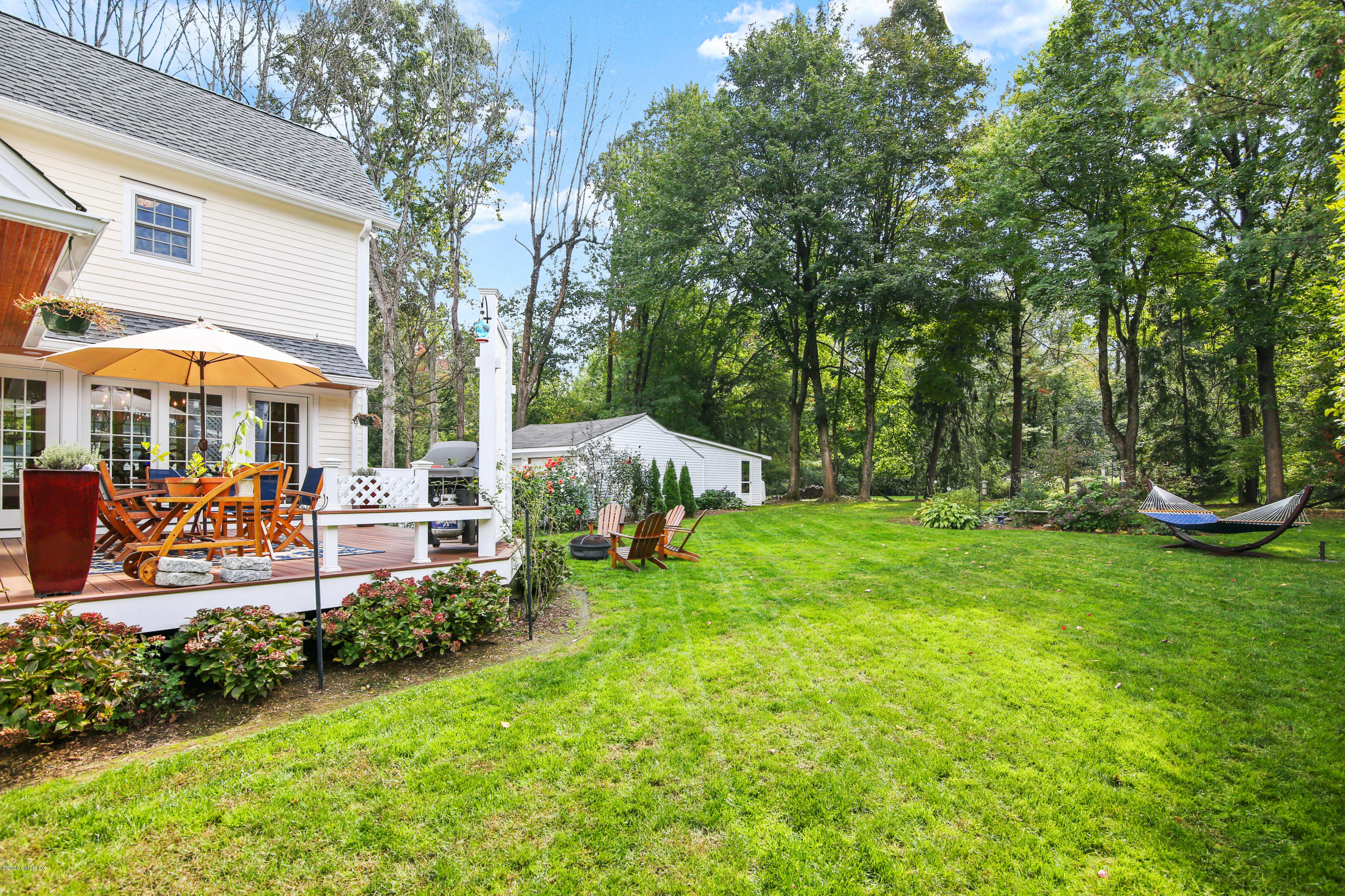 20 Scott Road Greenwich, CT 06831 - Photo 33 of 42 a view of a patio with table and chairs under an umbrella