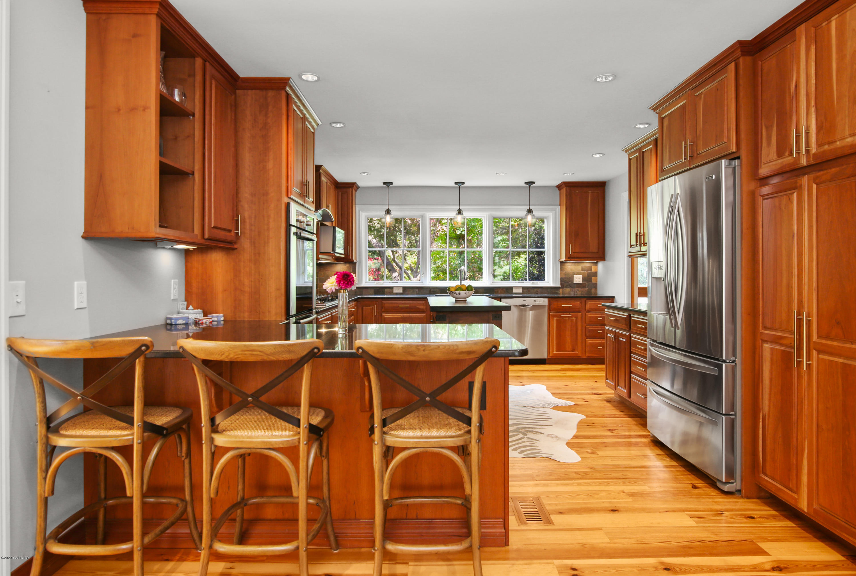 20 Scott Road Greenwich, CT 06831 - Photo 10 of 42 a kitchen with stainless steel appliances granite countertop a refrigerator a stove a sink dishwasher and wooden cabinets with wooden floor