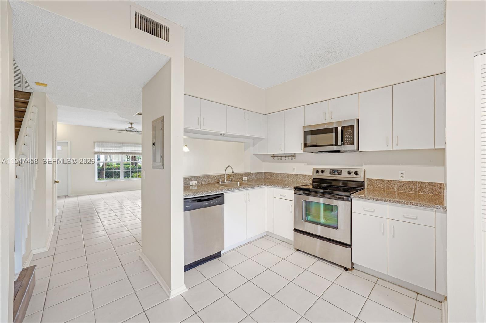 4 Key W Court, Unit 4 Weston, FL 33326 - Photo 12 of 29 a kitchen with white cabinets and appliances