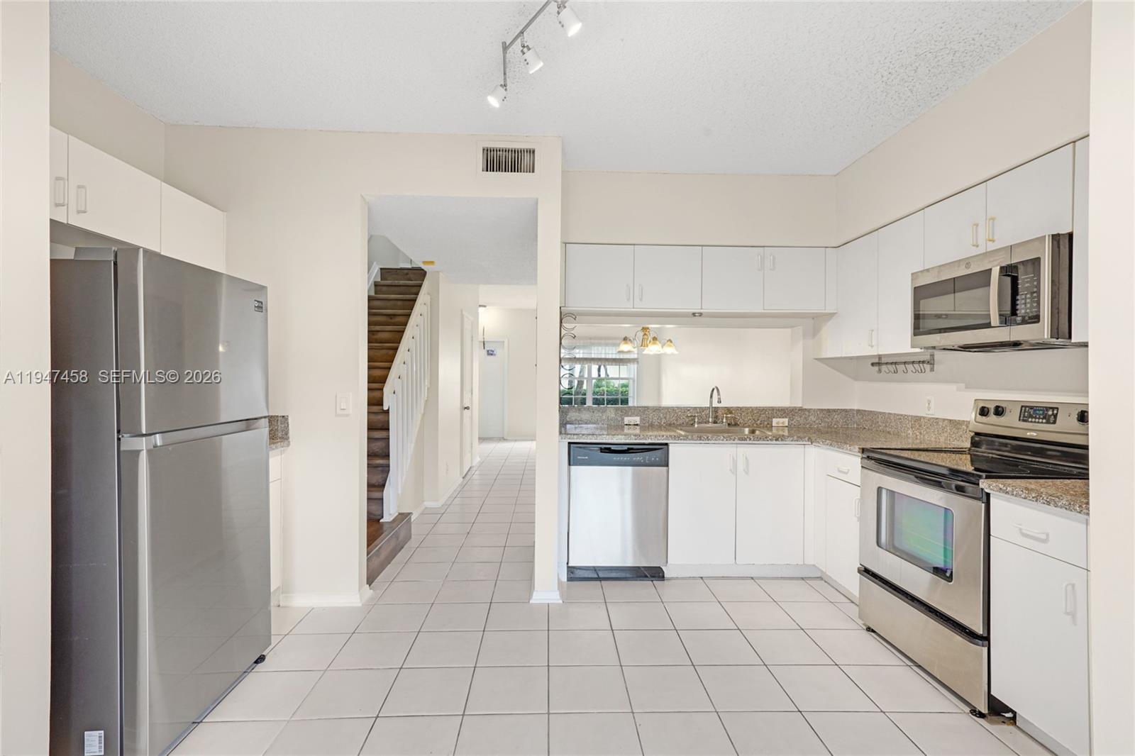 4 Key W Court, Unit 4 Weston, FL 33326 - Photo 3 of 29 a kitchen with granite countertop a refrigerator and a stove top oven