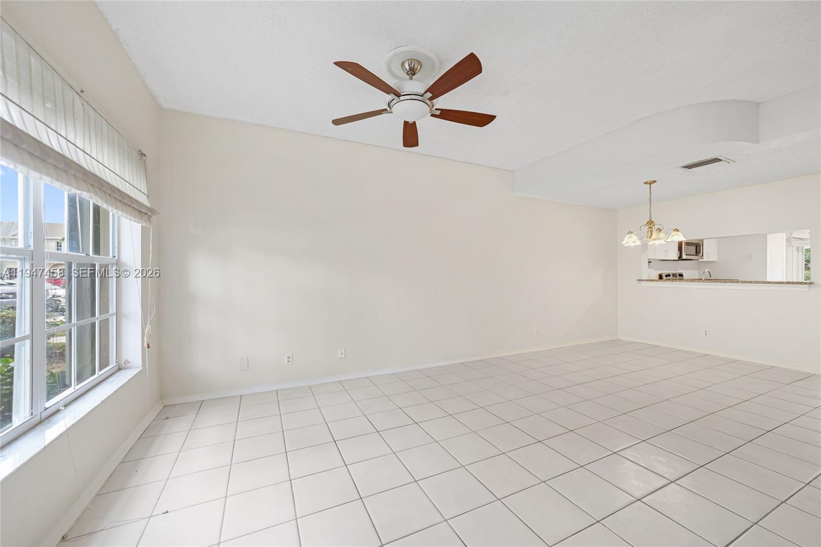 4 Key W Court, Unit 4 Weston, FL 33326 - Photo 4 of 29 wooden floor in an empty room with a ceiling fan and window