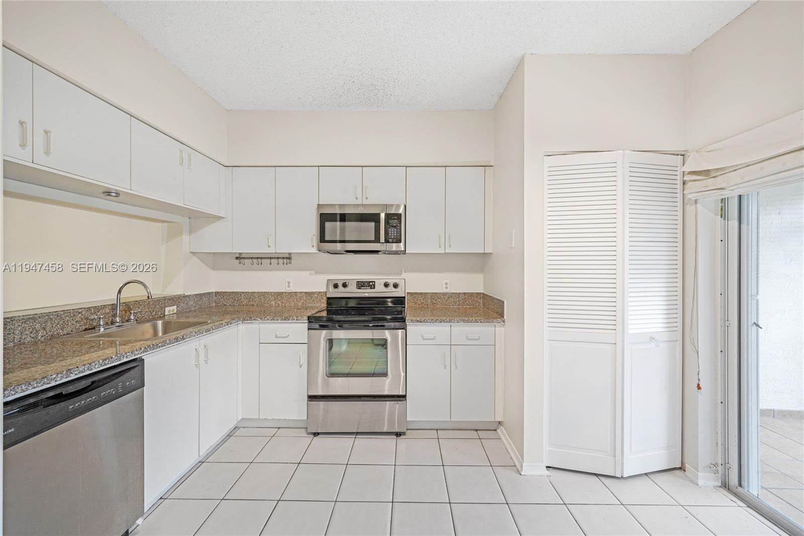 4 Key W Court, Unit 4 Weston, FL 33326 - Photo 10 of 29 a kitchen with white cabinets a sink stove and refrigerator