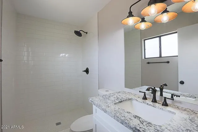a bathroom with a granite countertop sink toilet and shower