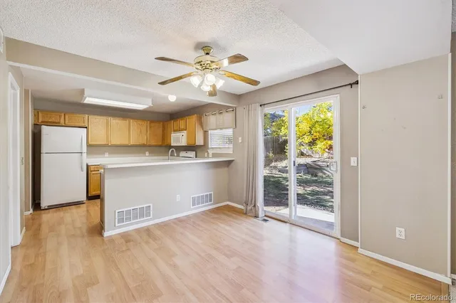 a view of a kitchen with wooden floor and a ceiling fan