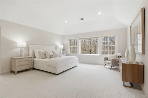 a spacious bedroom with a bed and large window