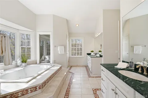 a spacious bathroom with a granite countertop tub sink and mirror