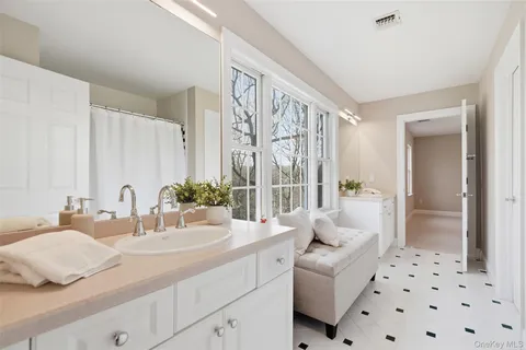 a en suite bathroom with a double vanity sink and large mirror