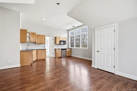 a view of empty room with wooden floor and window