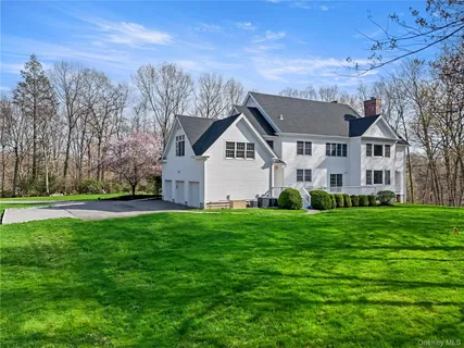 a view of a big house with a big yard and large trees
