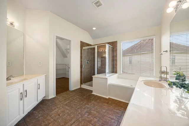 a spacious bathroom with a tub shower and sink
