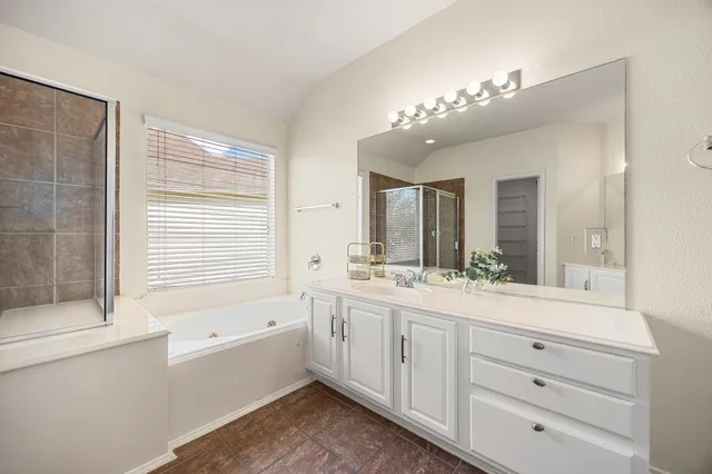 a spacious bathroom with a granite countertop sink mirror and a bathtub