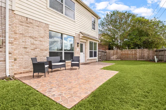 a view of a house with backyard and a tree