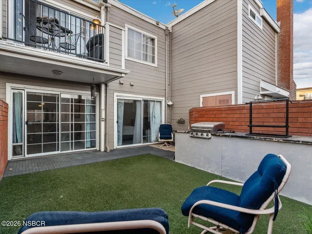 a backyard of a house with table and chairs