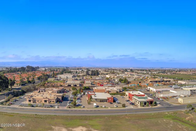 an aerial view of residential houses with outdoor space and trees