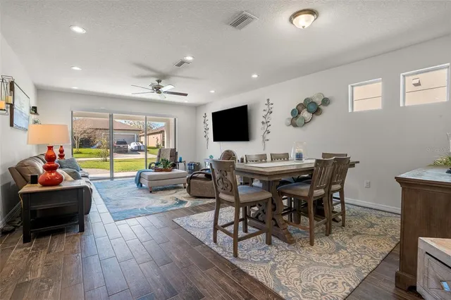 a view of a dining room with furniture a rug and wooden floor