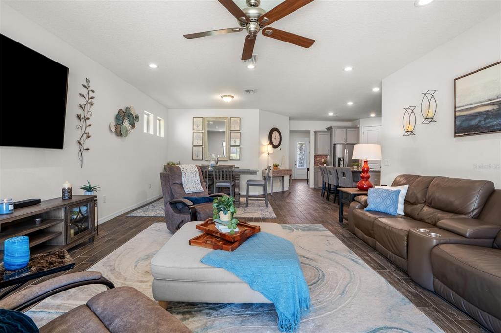 2825 Murray Pass Odessa, FL 33556 - Photo 13 of 43 a living room with furniture and a flat screen tv with kitchen view