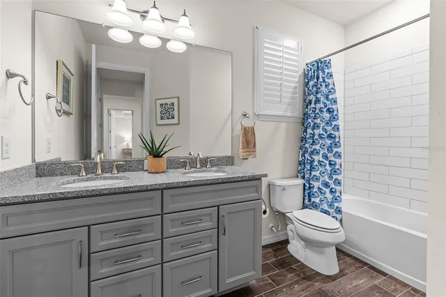 a bathroom with a granite countertop sink a toilet and a bathtub