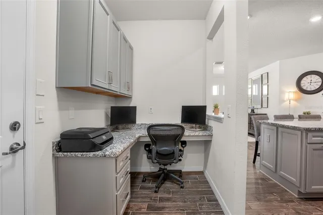 a view of a workspace with furniture and a window