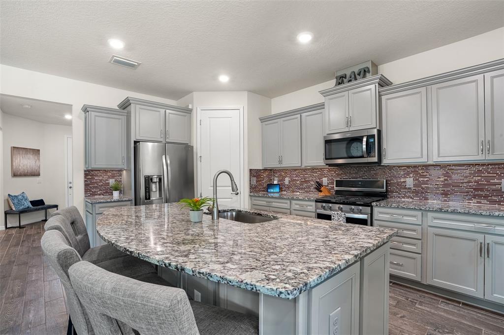 2825 Murray Pass Odessa, FL 33556 - Photo 7 of 43 a kitchen with kitchen island granite countertop a sink counter top space appliances and cabinets