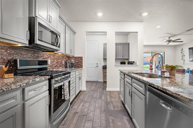a kitchen with stainless steel appliances granite countertop a stove and a sink
