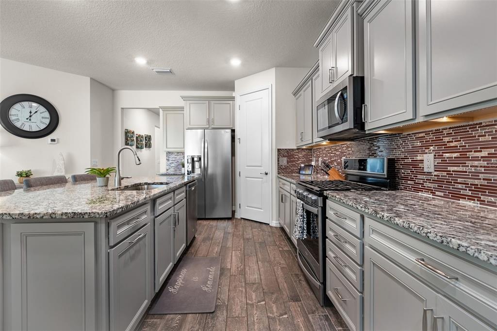 2825 Murray Pass Odessa, FL 33556 - Photo 10 of 43 a kitchen with stainless steel appliances granite countertop a stove a sink and a refrigerator
