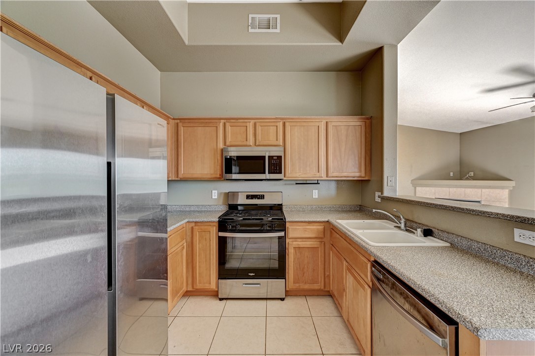 8985 South Durango Drive, Unit 2187 Las Vegas, NV 89113 - Photo 2 of 73 A functional kitchen with light wood cabinetry and modern stainless steel appliances.