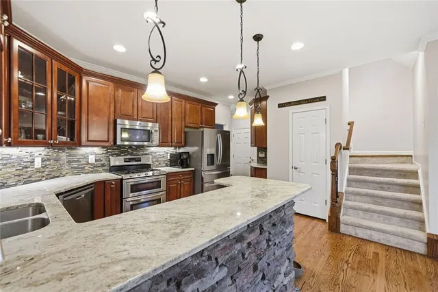 a kitchen with stainless steel appliances granite countertop a sink stove and refrigerator