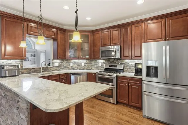 a kitchen with stainless steel appliances granite countertop wooden cabinets a sink and a stove
