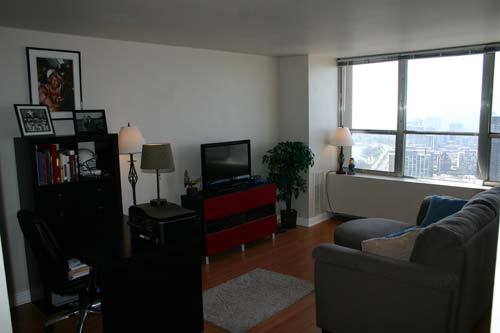 655 West Irving Park Road, Unit 5209 Chicago, IL 60613 - Photo 2 of 15 a living room with furniture and a flat screen tv