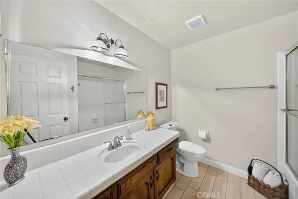 a bathroom with a granite countertop sink a toilet and a mirror