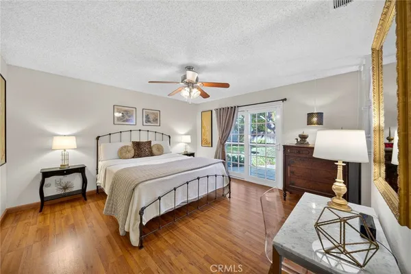 a bedroom with a bed a window and wooden floor