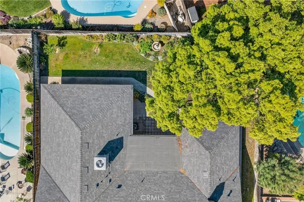 an aerial view of a brick house with a yard and plants
