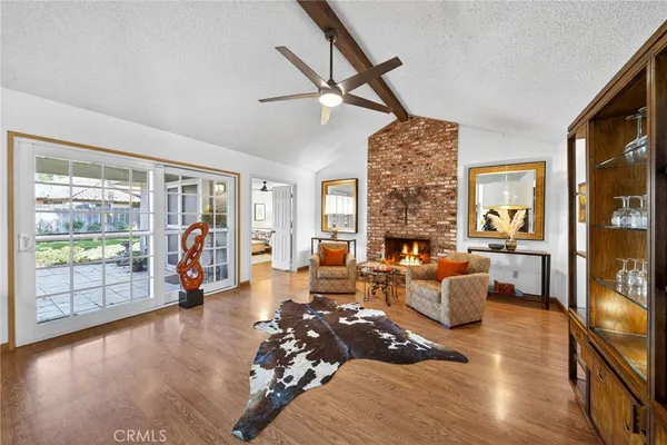 a living room with furniture large window and wooden floor