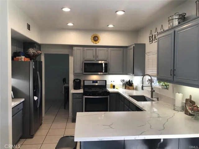 a kitchen with stainless steel appliances a sink a stove a refrigerator and cabinets