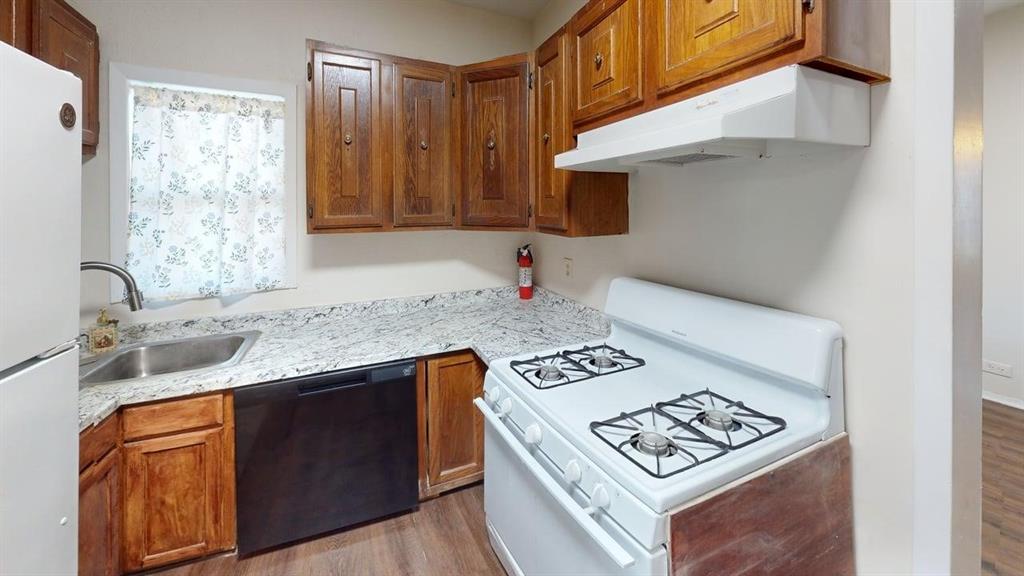 224 West Hull Street, Unit B Denison, TX 75020 - Photo 7 of 13 Kitchen with white appliances, wood finish cabinets, and light wood-style flooring