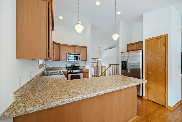a kitchen with stainless steel appliances granite countertop a sink a stove and a refrigerator