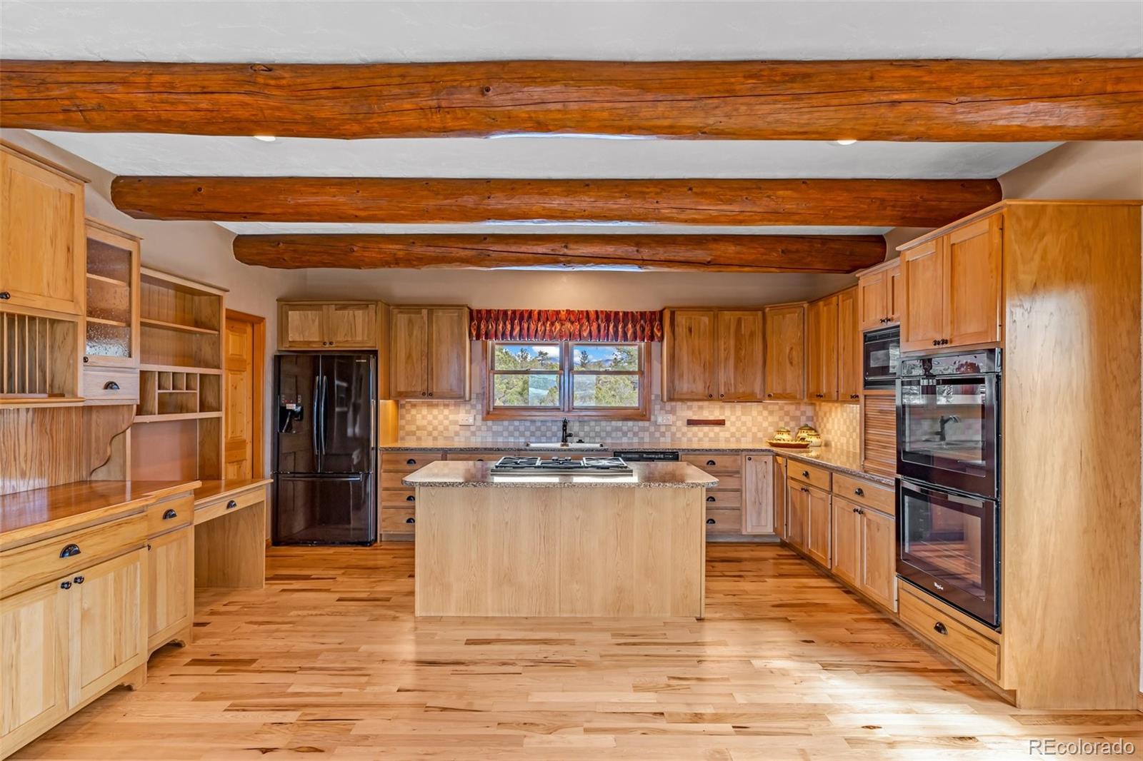 4230 Timber Ridge Road Westcliffe, CO 81252 - Photo 12 of 37 a kitchen with stainless steel appliances kitchen island granite countertop a stove and a refrigerator