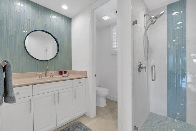 a spacious bedroom with a bed and a lamp on a dresser