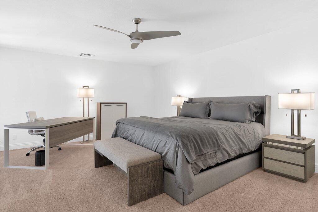 6 Barnard Court Rancho Mirage, CA 92270 - Photo 13 of 50 a spacious bedroom with a bed and a lamp on a dresser