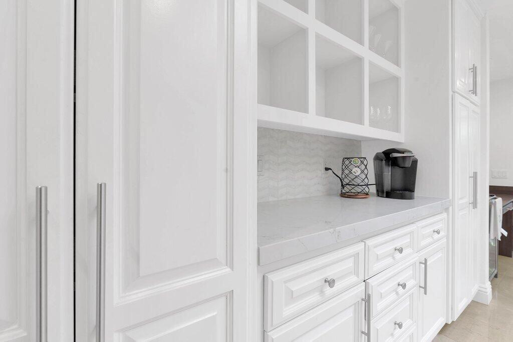 6 Barnard Court Rancho Mirage, CA 92270 - Photo 16 of 50 a kitchen with white cabinets and a sink