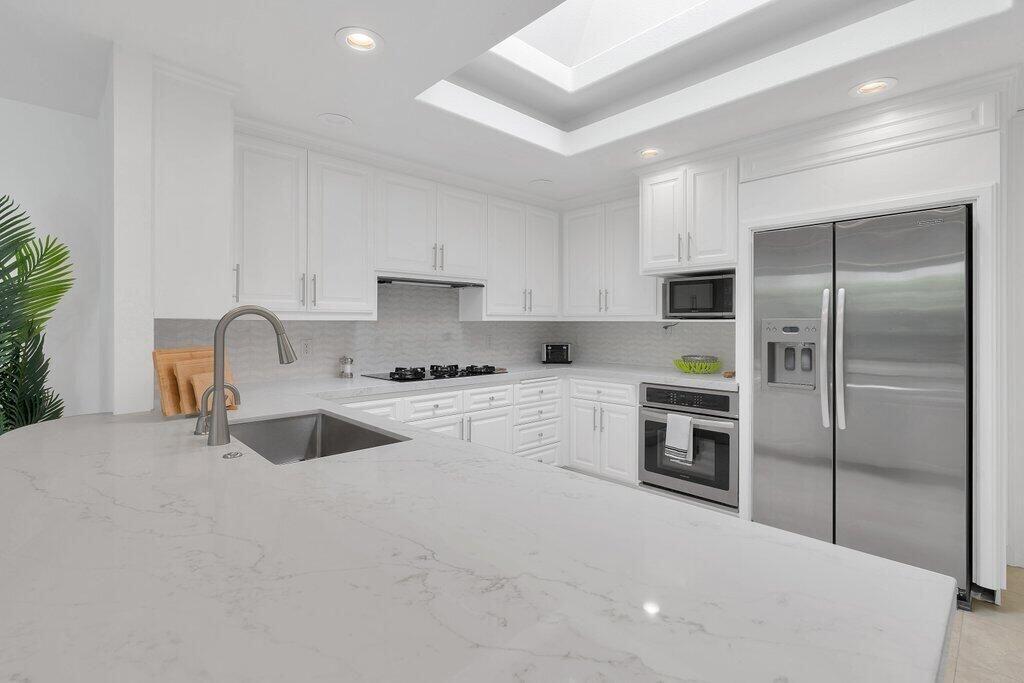 6 Barnard Court Rancho Mirage, CA 92270 - Photo 19 of 50 a kitchen with granite countertop a refrigerator sink and stove
